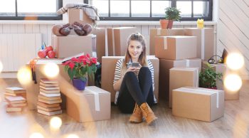 mulher com caixas vendo aplicativo de transporte de carga